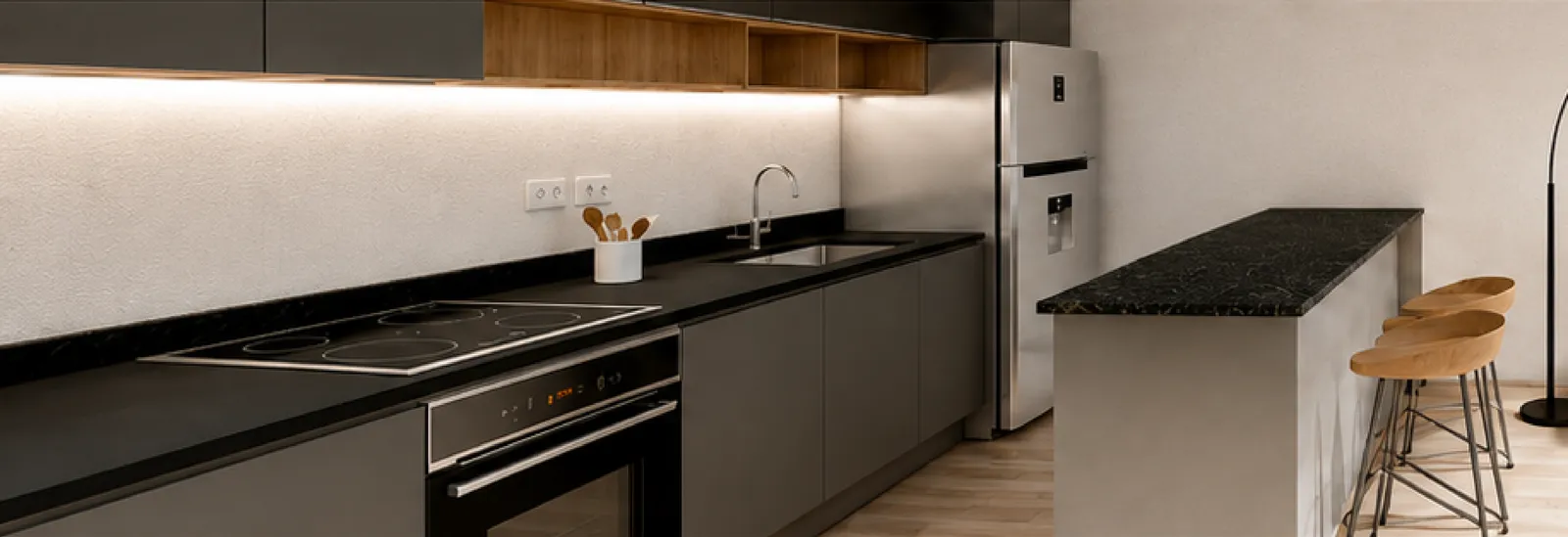 Cocina equipada con anafe, horno y mesada oscura